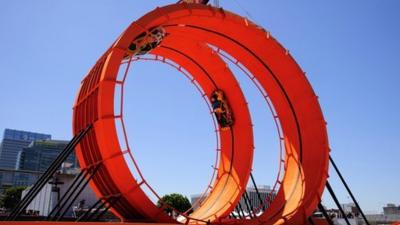 Two cars do a loop the loop on 18 metre high rings