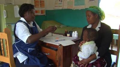 A health worker with a mother and baby