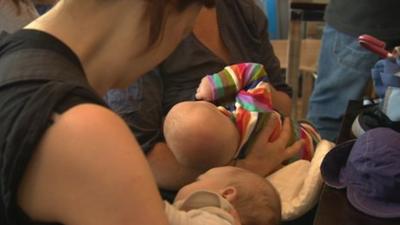 Breast-feeding mothers gather at a cafe in Bristol to protest against the way another mother was treated.