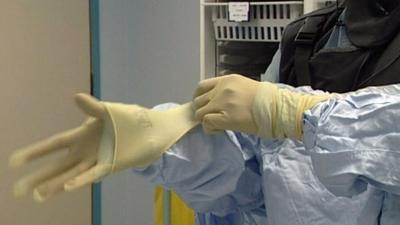 Surgeon putting on his scrubs ahead of an exploratory heart operation