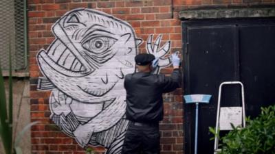 A mural being put on a wall in Dalston