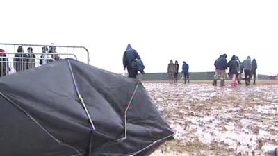 Broken umbrella sits in the mud