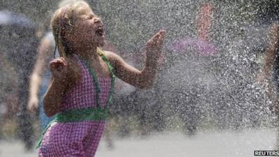 A girl runs through a water fountain Washington DC 5 July 2012