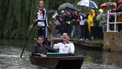 Edward Roberts carries the Olympic Flame on a punt on the River Cam on 8/7/12