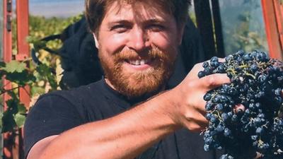 John Wurdeman holding grapes