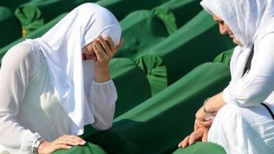 Women weep over a relative's coffin