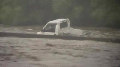 Van swept along in flood waters