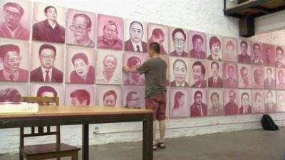 Beijing artist Zhang Bingjian hanging a portrait of a corrupt official in his 'Hall of Fame'