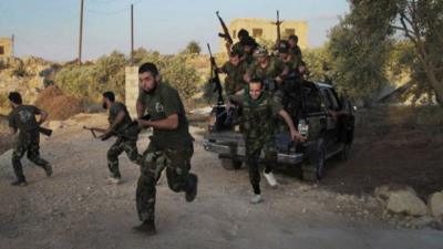 Fighters of the Free Syrian Army run for cover