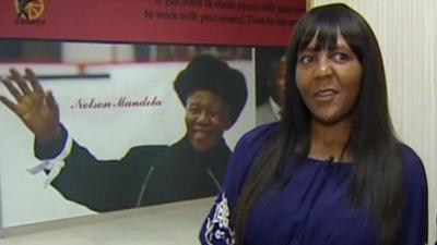 Ndileka Mandela in front of picture of Nelson Mandela