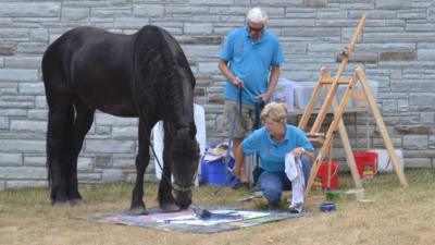 Justin the horse painting with his owner.