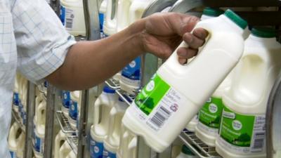 Man taking milk off shelf