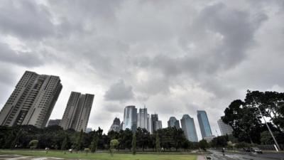 Dark clouds hang over the skyline of downtown Jakarta