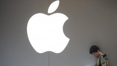 A customer uses his iPad outside an Apple store in Shanghai