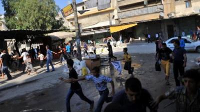 Syrians run for cover as a helicopter flies over Aleppo (24 Jul 2012)