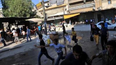 Syrians run for cover as a helicopter flies over Aleppo (24 Jul 2012)