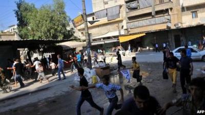 Syrians run for cover as a helicopter flies over Aleppo (24 Jul 2012)