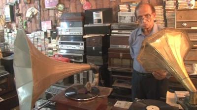 Mian Abdul Quddus standing with two gramophones