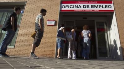 Jobseekers queue up outside a job centre in Madrid