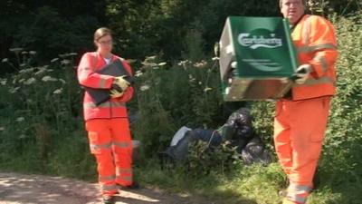 Workers collecting fly-tipped waste