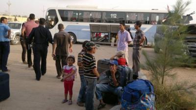 Syrians are seen at the Abu Kamal Iraqi-Syrian border