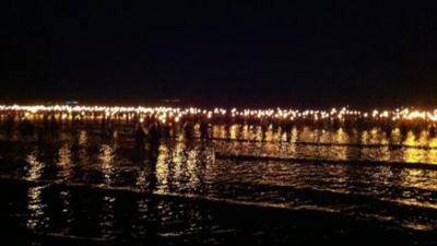 Torchbearers walk into the sea at Weymouth