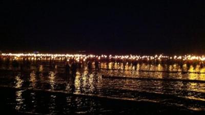 Torchbearers walk into Weymouth Bay