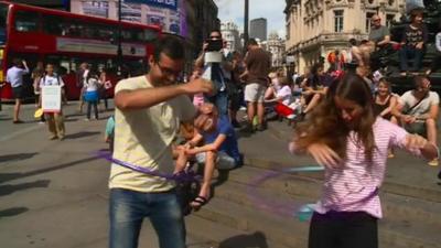 Tourists try their hand at rhythmic gymastics in central London