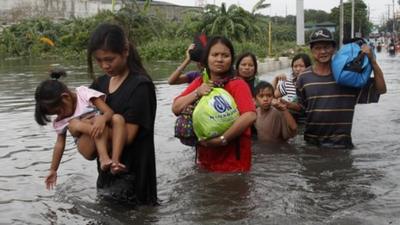 Residents wade through water