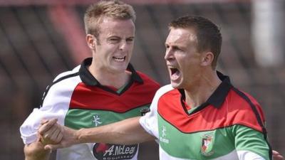 Glentoran's Richard Clarke celebrates with goalscorer Jay Magee