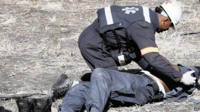 An injured policeman is tended after he was attacked and injured by striking Lonmin miners near Rustenburg.