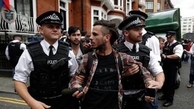 Police detain a supporter of Julian Assange, the founder of the WikiLeaks website, for obstructing the highway outside the Ecuadorean Embassy