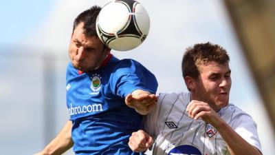 Linfield's Jim Ervin beats Coleraine's Stephen Lowry to the ball