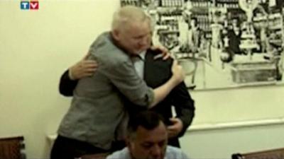 Julian Assange receiving a hug from his lawyer in the Ecuadorian embassy