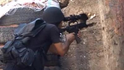 Man aims weapon through hole in wall