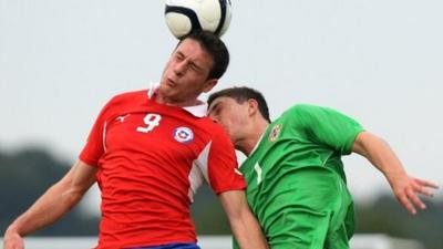 Chile's Angelo Henriquez wins an aerial battle against Northern Ireland's Jordan Watson in the Milk Cup Elite Section.