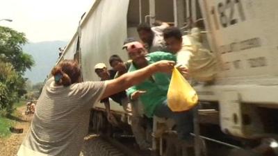 One of the 'patronas' handing out food and drink to the immigrants