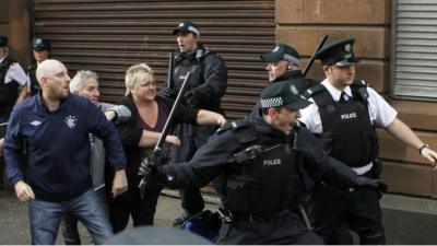 Police officer attempt to stop fighting outside St Patrick"s Roman Catholic Church in Belfast