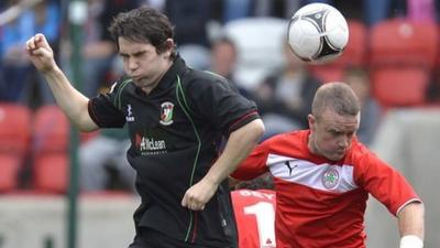 Glentoran's Eamon Murray contests an aerial challenge with Cliftonville's Barry Holland