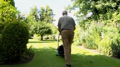 Dr Chisholm Ogg mowing his lawn