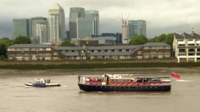 Torch transported on boat in front of Canary Wharf