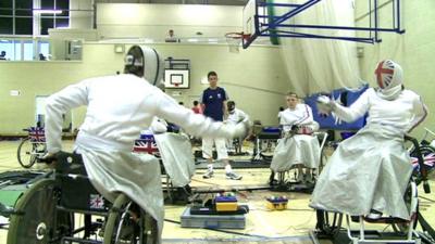 Wheelchair fencing athletes in practice hall