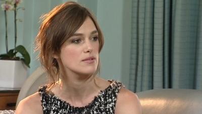 Keira Knightley being interviewed and wearing a black and white dress.