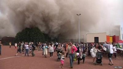 People flee dust cloud after building demolition