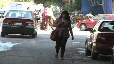 A woman walks down a street in Cairo