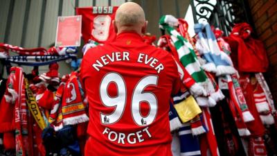 Man stood at the Shankly gates at Liverpool football club