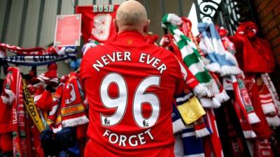 Man stood at the Shankly gates at Liverpool football club