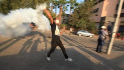 Protester in Cairo throwing a cannister of tear gas