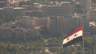 Syrian flag flying over city