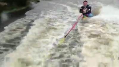 Oli Barrett being towed on a surfboard along Castleford in West Yorkshire